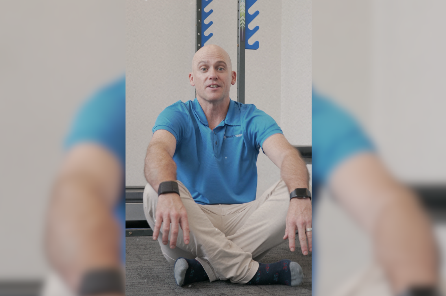 Health professional demonstrating the importance of muscle strength and flexibility by sitting cross-legged on the floor at My Health Team clinic in Redcliffe. This pose highlights core stability and mobility, key aspects of maintaining physical health as we age.